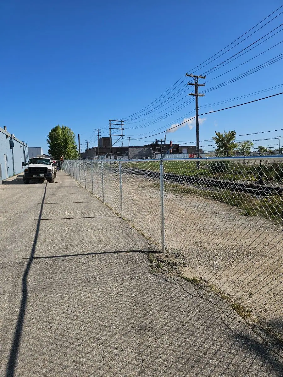 Chainlink perimeter fence with barbed-wire arms