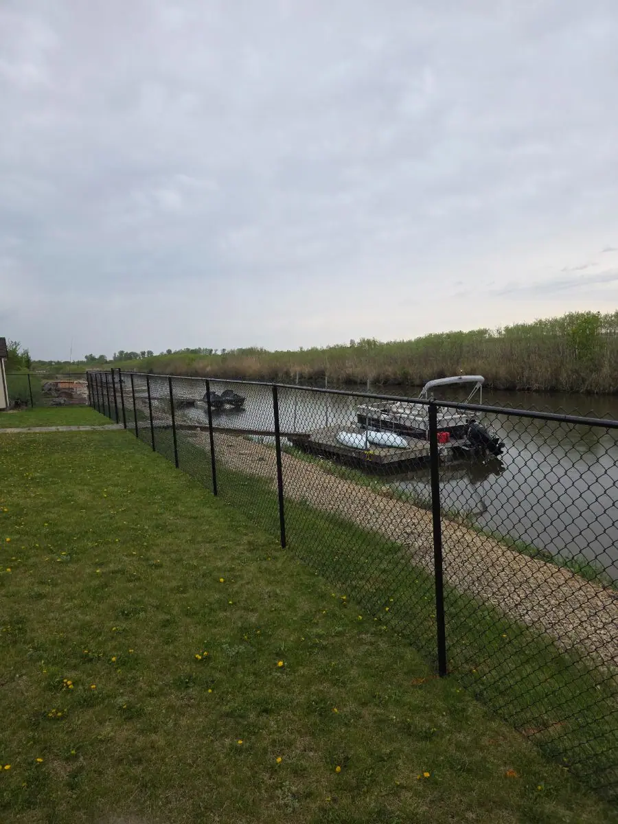 Black chainlink fence along the river